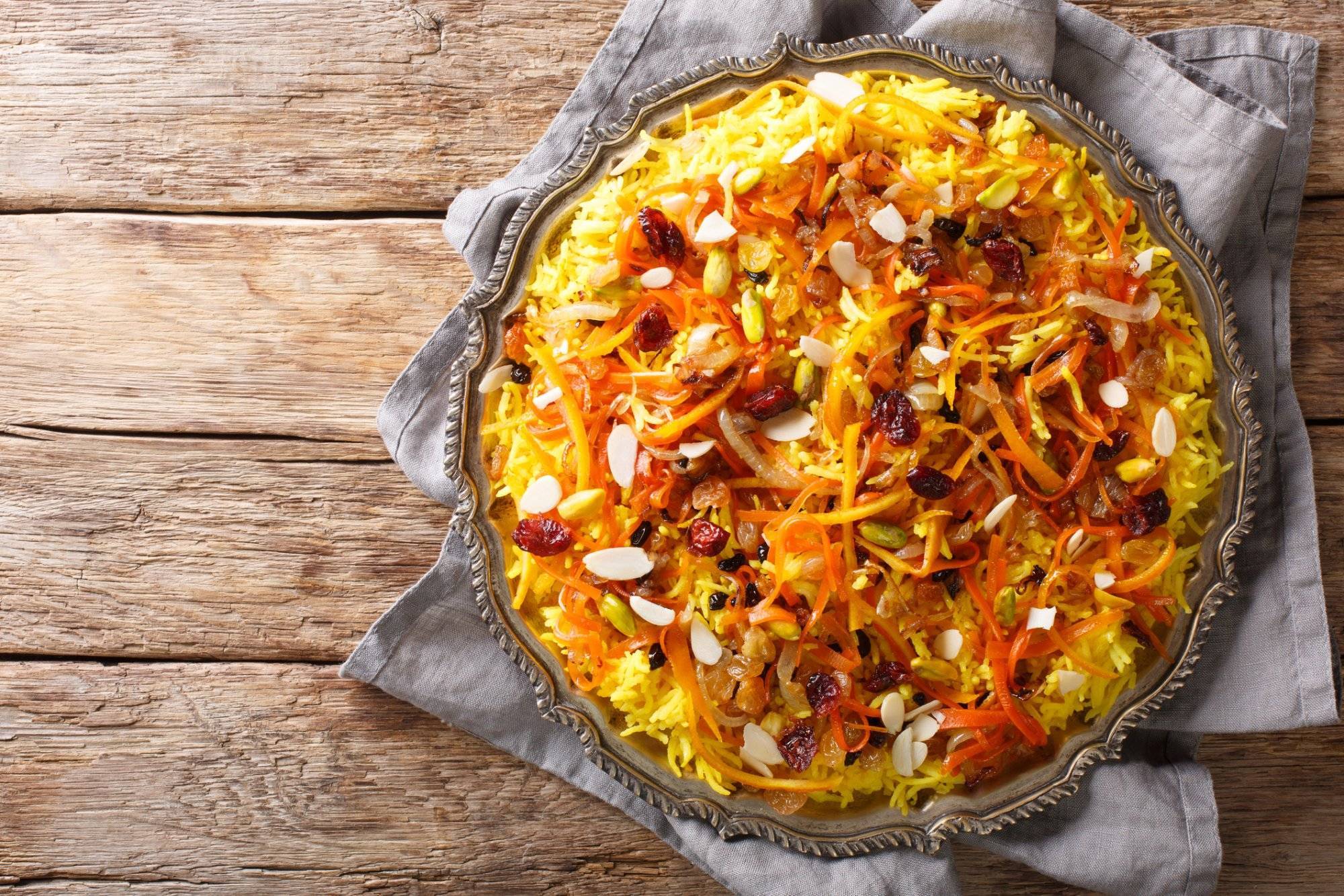 Javaher Polow (jeweled rice) is a traditional Persian rice dish closeup on a plate. horizontal top view